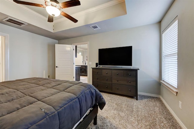 bedroom with ensuite bathroom, ornamental molding, ceiling fan, a raised ceiling, and light carpet