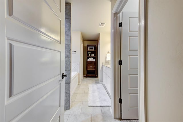 bathroom featuring tile patterned flooring, vanity, and a tub