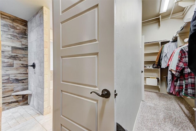 bathroom featuring tile patterned flooring and tiled shower