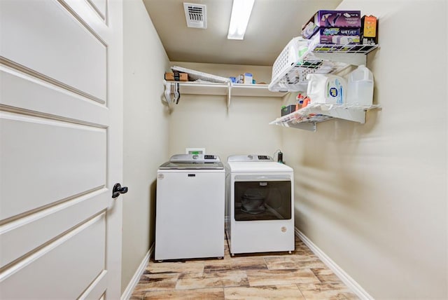 washroom with washing machine and dryer and light wood-type flooring