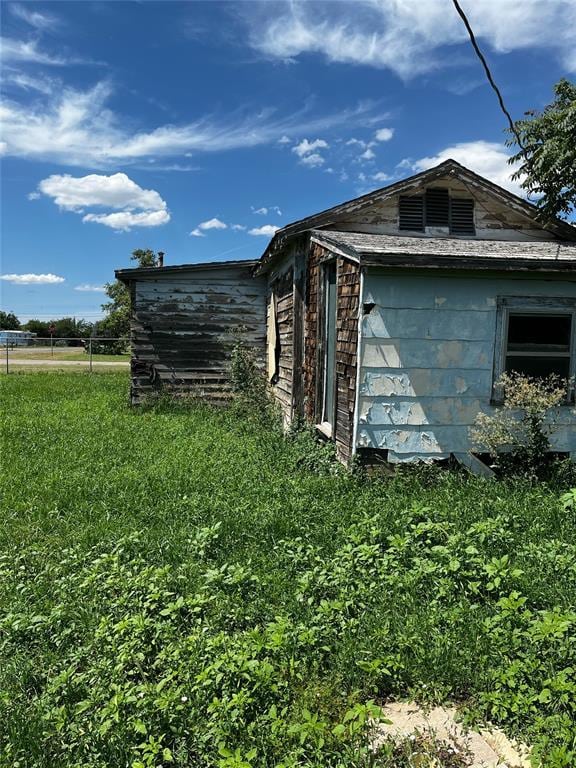 view of home's exterior with an outbuilding and a yard