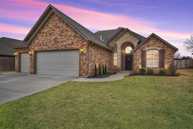 view of front of house with a garage and a yard