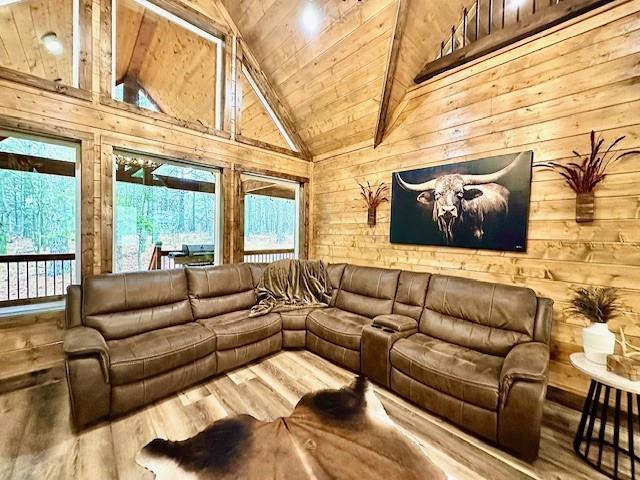 living room featuring wood-type flooring, plenty of natural light, wooden ceiling, and wood walls