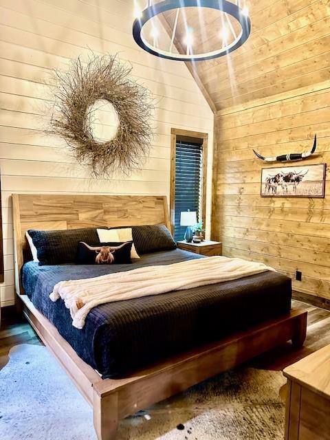 bedroom featuring lofted ceiling, wood ceiling, wood-type flooring, and wood walls