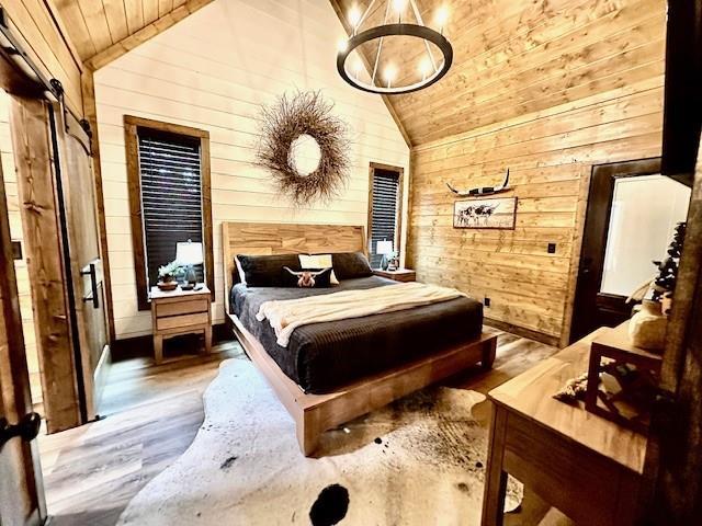 bedroom featuring vaulted ceiling, wooden ceiling, and wood walls