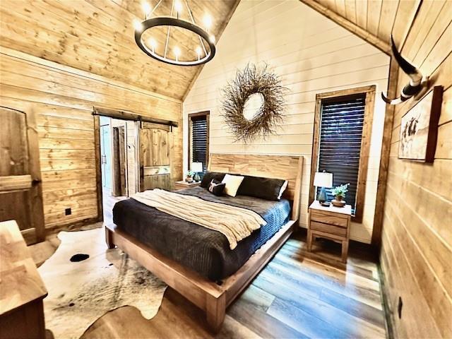 bedroom with high vaulted ceiling, wooden walls, hardwood / wood-style flooring, a notable chandelier, and wooden ceiling