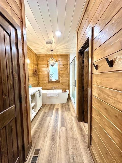 bathroom featuring hardwood / wood-style floors, wood ceiling, plus walk in shower, and wood walls