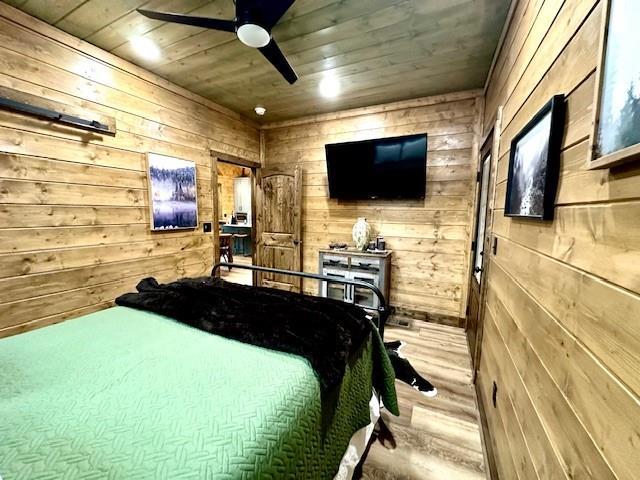 bedroom with wood ceiling, light hardwood / wood-style flooring, and wood walls