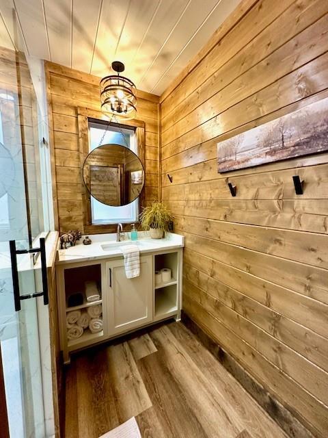 bathroom featuring wooden ceiling, wood-type flooring, vanity, and wood walls