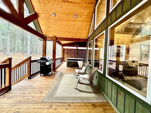 deck with a hot tub and grilling area