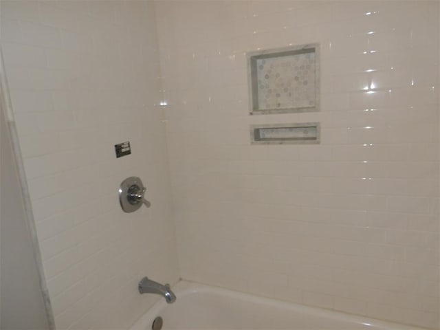 interior details with tiled shower / bath combo