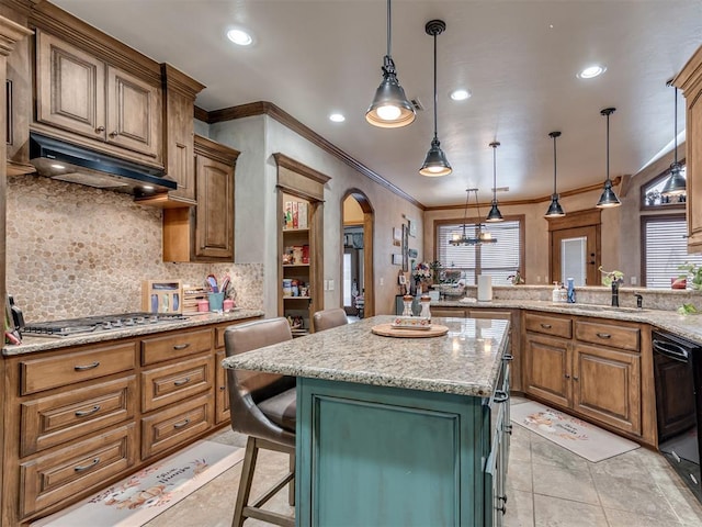 kitchen featuring custom range hood, a breakfast bar, a center island, stainless steel gas stovetop, and pendant lighting