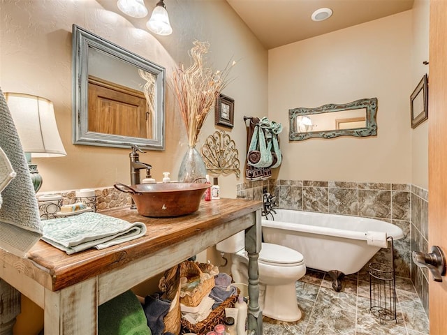 bathroom featuring sink, a tub, and toilet