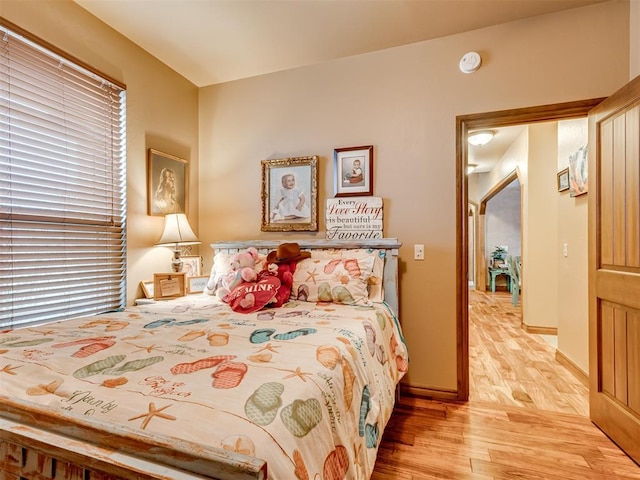 bedroom featuring light wood finished floors and baseboards