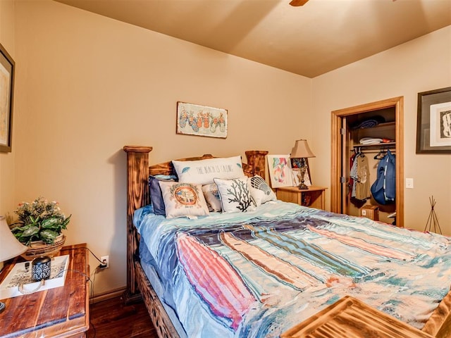 bedroom with a walk in closet and dark wood-style flooring