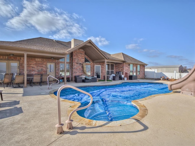 view of pool featuring a patio area, a fenced in pool, fence, and a water slide