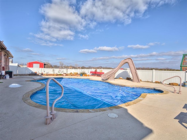 view of pool with a water slide, a patio area, a fenced backyard, and a fenced in pool