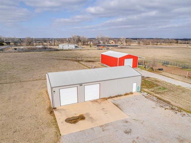 view of pole building with a rural view and fence