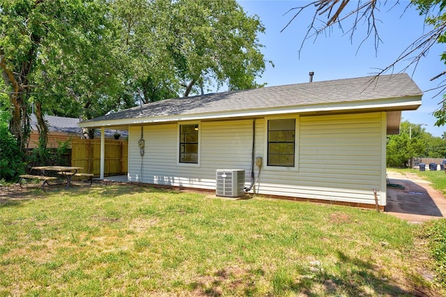 back of property featuring cooling unit and a yard