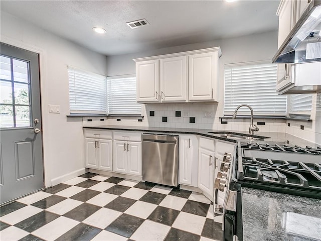 kitchen featuring sink, white cabinetry, stainless steel appliances, decorative backsplash, and exhaust hood