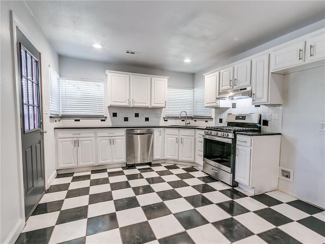 kitchen featuring a healthy amount of sunlight, sink, white cabinets, and appliances with stainless steel finishes