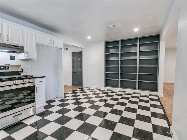 kitchen with white cabinetry, stainless steel range with gas cooktop, and backsplash