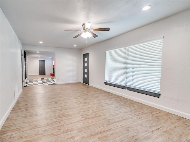 empty room featuring ceiling fan and light hardwood / wood-style floors