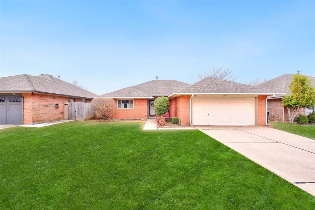 ranch-style home with a garage and a front lawn