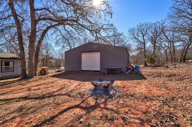 view of outbuilding with a garage and a fire pit