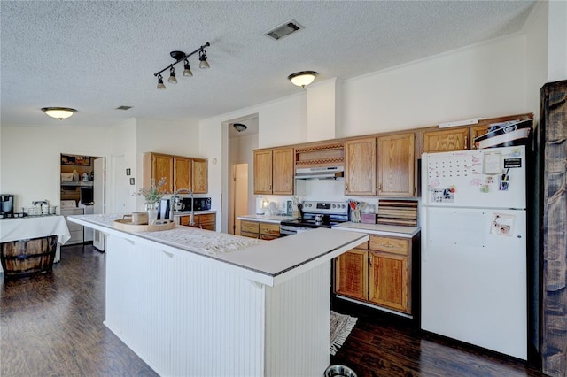 kitchen with lofted ceiling, stainless steel range with electric stovetop, white refrigerator, an island with sink, and dark hardwood / wood-style flooring