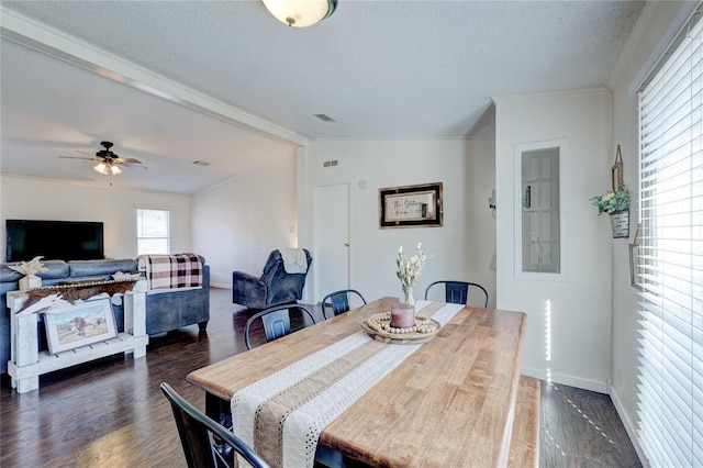 dining room with ceiling fan, dark hardwood / wood-style floors, a textured ceiling, and vaulted ceiling with beams