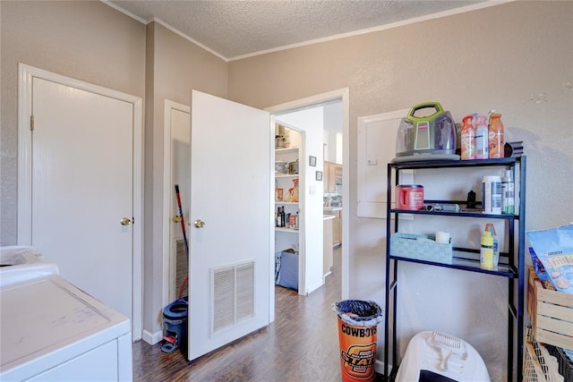 kitchen with dark wood-type flooring, crown molding, washing machine and dryer, and a textured ceiling