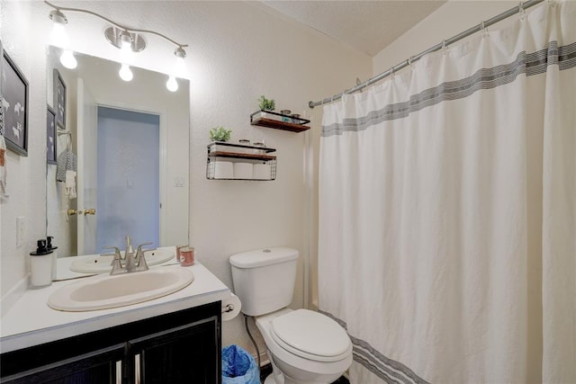 bathroom with vanity, curtained shower, a textured ceiling, and toilet