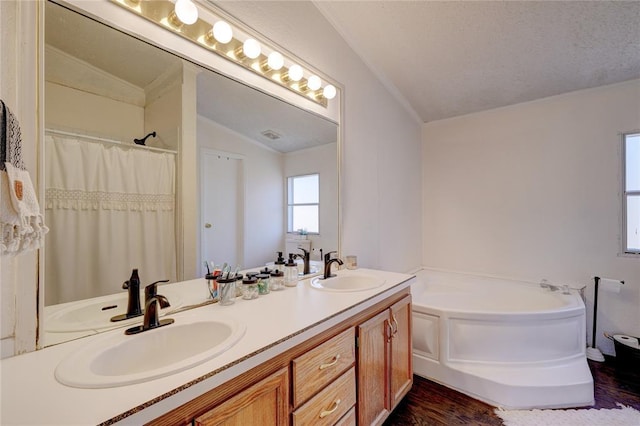 bathroom featuring lofted ceiling, vanity, hardwood / wood-style floors, and a bathing tub