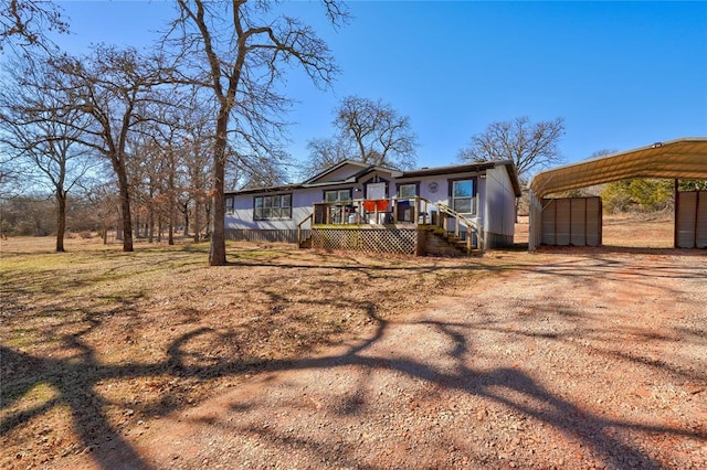 view of front facade featuring a wooden deck and a carport