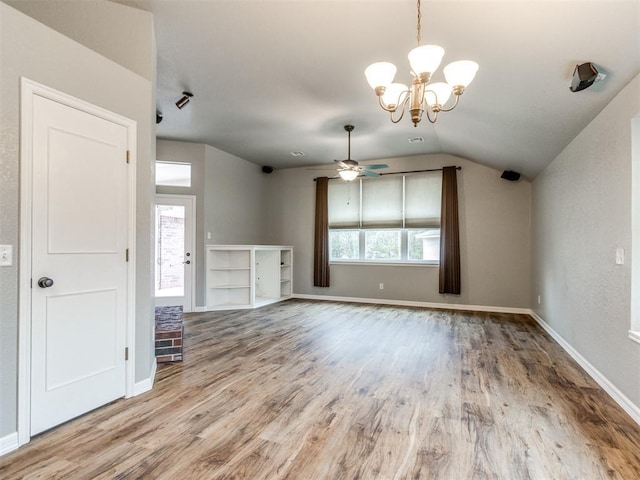 interior space featuring ceiling fan with notable chandelier, lofted ceiling, a wealth of natural light, and light wood-type flooring