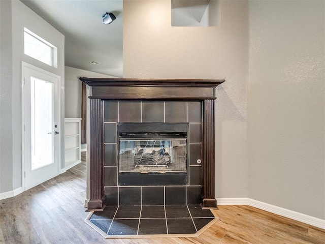 room details featuring wood-type flooring and a tile fireplace