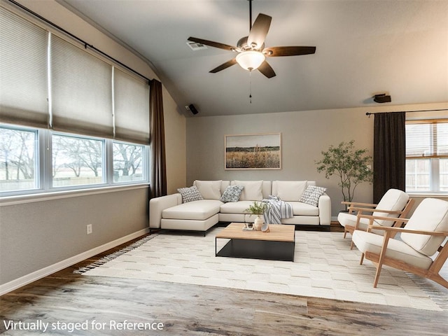 living room with ceiling fan, lofted ceiling, and light hardwood / wood-style flooring