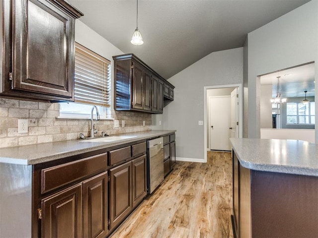 kitchen with lofted ceiling, sink, hanging light fixtures, stainless steel dishwasher, and dark brown cabinetry