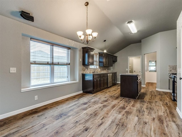 kitchen featuring wood-type flooring, decorative backsplash, hanging light fixtures, a center island, and dark brown cabinetry