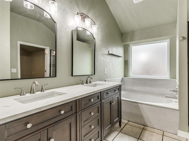 bathroom featuring vanity, tile patterned floors, a bathing tub, and lofted ceiling