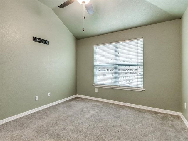 carpeted spare room featuring lofted ceiling and ceiling fan