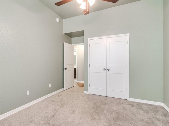 unfurnished bedroom featuring light carpet, a closet, and ceiling fan