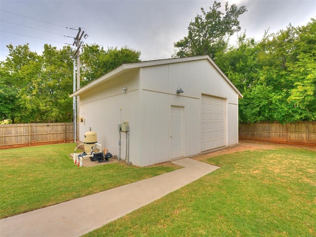 view of outdoor structure featuring a garage and a lawn