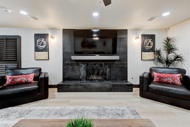 living room with hardwood / wood-style flooring and a tile fireplace