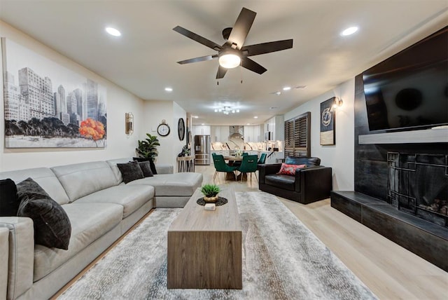 living room with ceiling fan and light hardwood / wood-style flooring