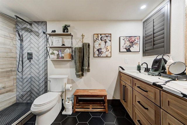 bathroom with vanity, tile patterned flooring, toilet, and a tile shower