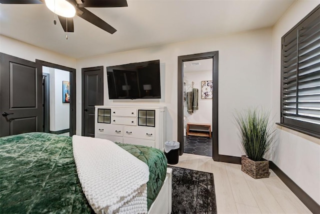 bedroom with ceiling fan, connected bathroom, and light wood-type flooring