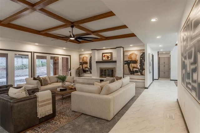 living room with coffered ceiling, a brick fireplace, beam ceiling, and ceiling fan