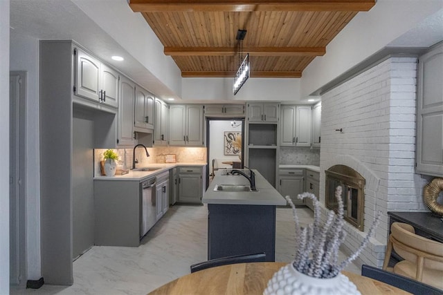 kitchen featuring tasteful backsplash, dishwasher, sink, and gray cabinetry